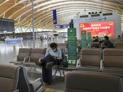 Passengers wearing face masks to help protect against the coronavirus take rest at Pudong International Airport in Shanghai, China on July 25, 2021. The United States is blocking some flights by Chinese airlines in retaliation for China canceling more than a dozen flights there by American carriers. The U.S. Transportation …