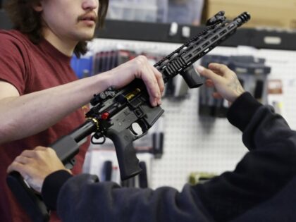 A salesperson shows an AR-15 rifle to a customer at a store in Orem, Utah, U.S., on Thursday, March 25, 2021. Two mass shootings in one week are giving Democrats new urgency to pass gun control legislation, but opposition from Republicans in the Senate remains the biggest obstacle to any …