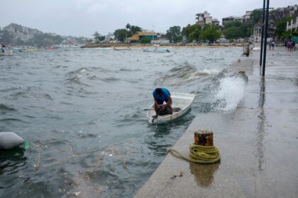 A man moors his boat in Acapulco on Mexico's Pacific coast as Storm Hilary passes offshore